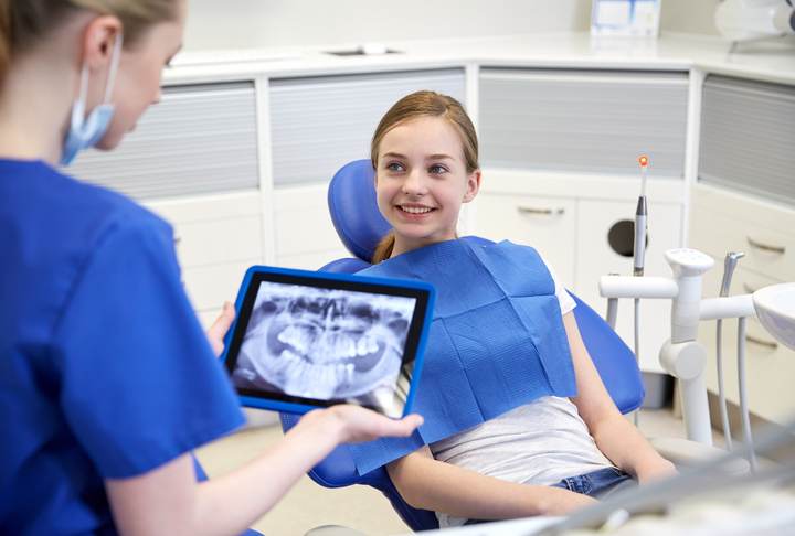 dentist with x-ray on tablet pc and patient girl