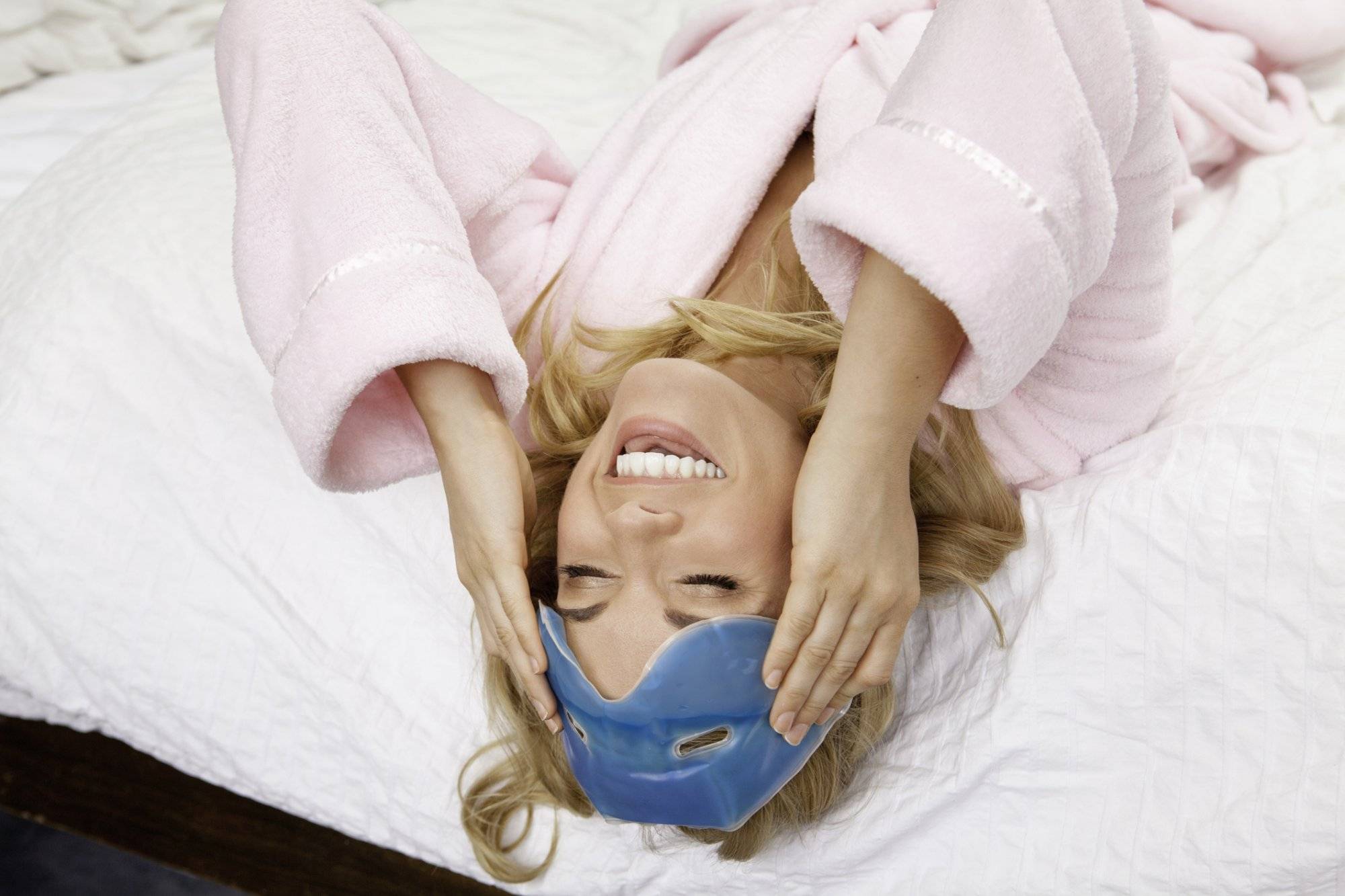 Woman on bed with eye mask on forehead