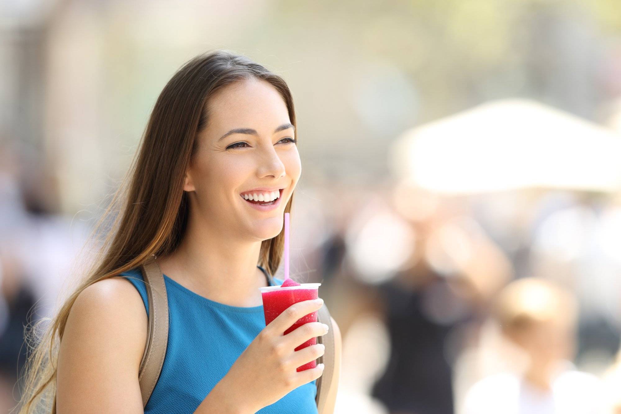 Happy woman walking and holding a slush