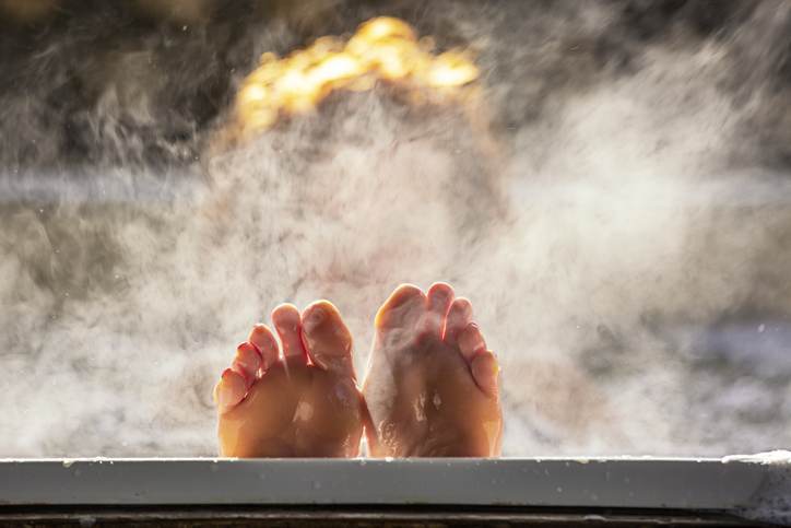 Woman holds her feet up while in a hot tub